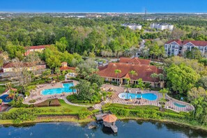 A resort with multiple swimming pools, a lake, and lush greenery. - Dog-friendly Townhouse With Heated Pool, Lazy River, hot Tub, Game Room, BBQ (Davenport)