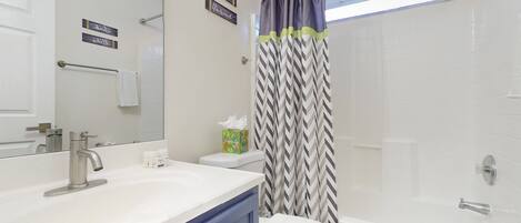Un baño con un lavamanos blanco, un inodoro, una ducha y un espejo.