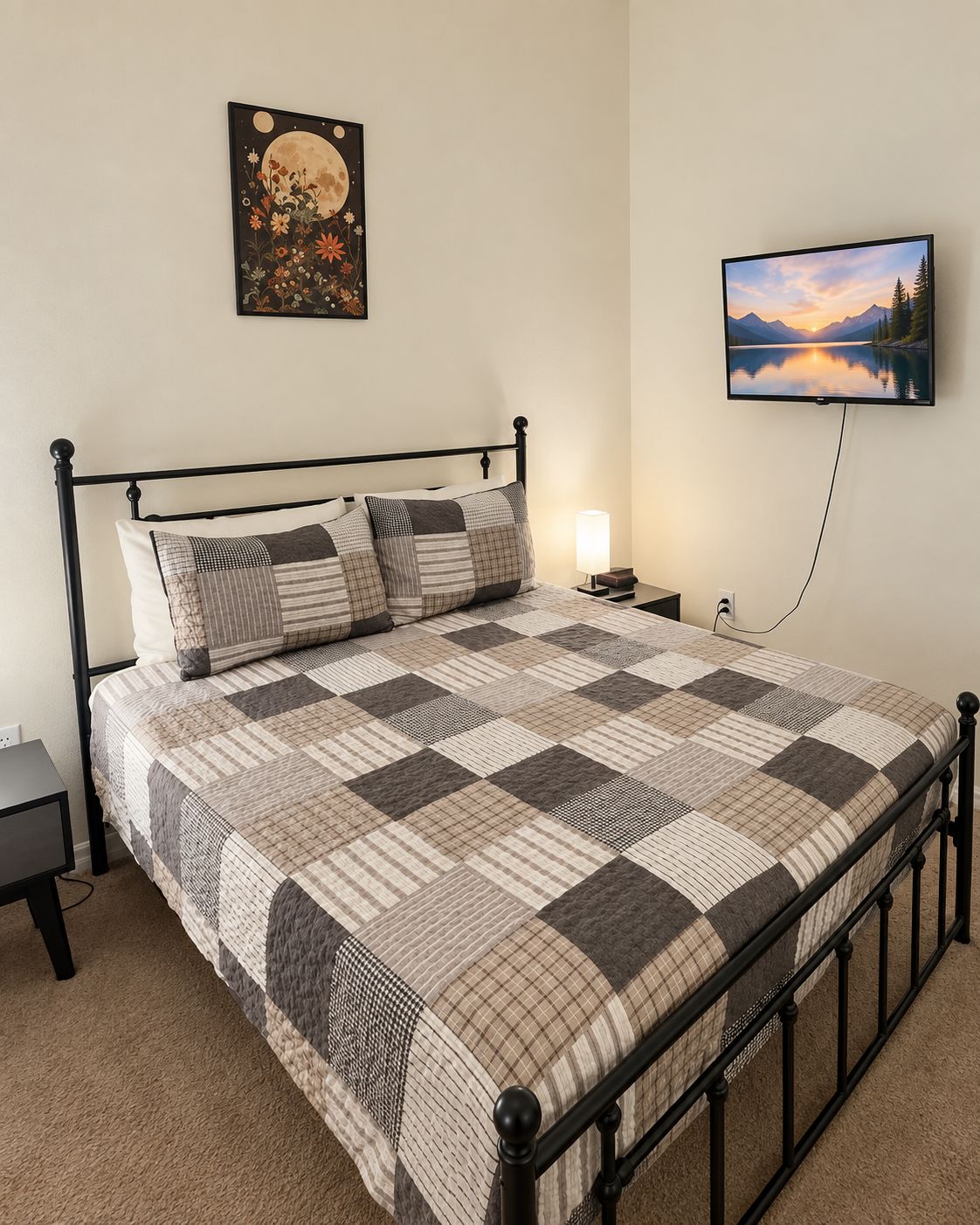 Quarto com cama, mesa de cabeceira, TV na parede e quadro emoldurado.