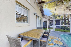 A covered patio with a pool, wicker furniture, and a patterned rug. - Radiant Retreat With Private Pool, On-site Golf, Board Games, AC, & W/D (Haines City)