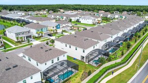 A residential area with houses, a swimming pool, and a road. - Dog-friendly Home With a Heated Pool, Pool Spa, In-home Theater, Lanai, & Patio (Kissimmee)