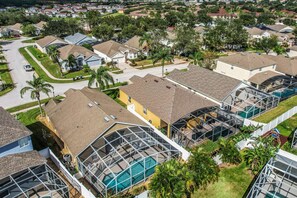 A residential area with houses, a swimming pool, and a covered outdoor area. - Inviting Villa With Private Pool & spa Near Disney & Golf Course Charm (Davenport)