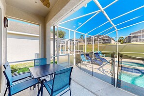 A covered patio area with a pool, outdoor seating, and a view of the pool area. - Inviting Villa With Private Pool & spa Near Disney & Golf Course Charm (Davenport)