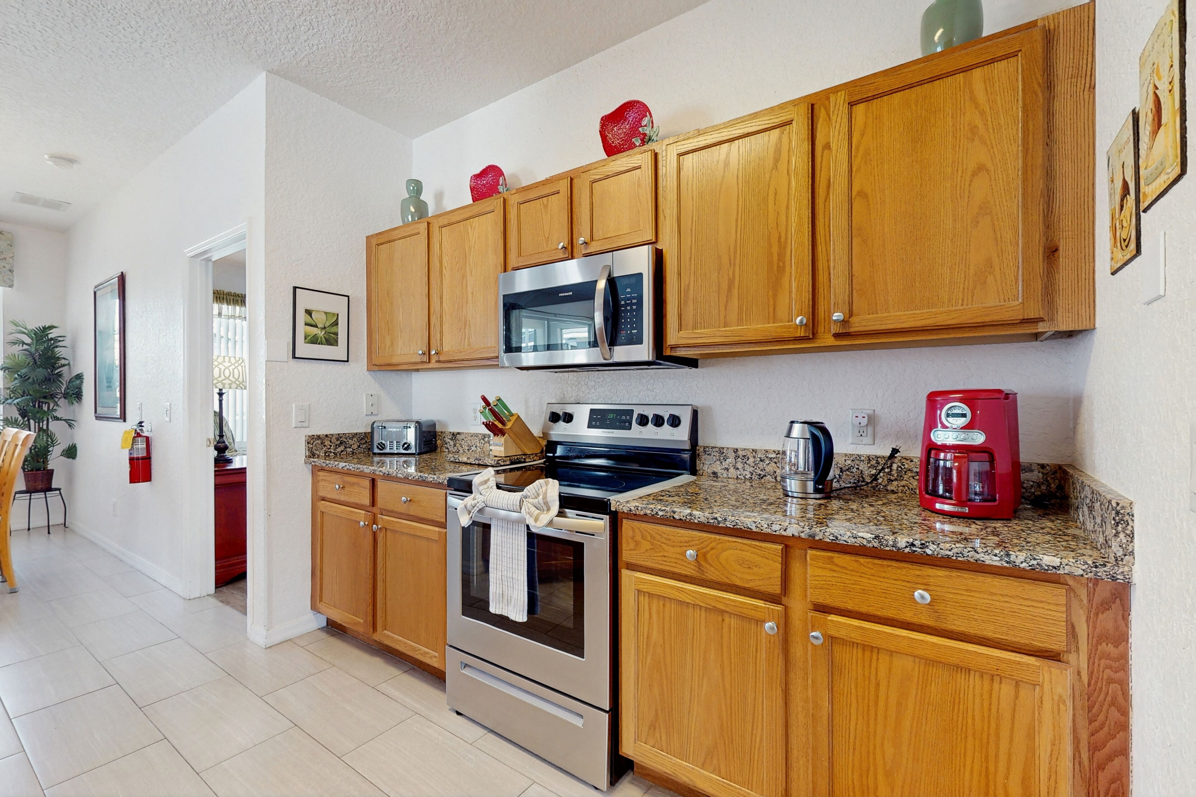 A modern kitchen with wooden cabinets, stainless steel appliances, and granite countertops.