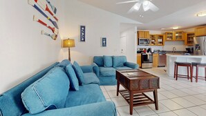 A living room with a sofa, a coffee table, and a ceiling fan. - Private Pool, Home Theater & Dog-friendly Retreat Near Disney (Kissimmee)