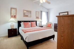 A bedroom with a bed, two bedside tables, a nightstand, a wooden dresser, and wall art. - Enchanting Dog-friendly Home With Pool, Lanai, Central AC, & Washer/dryer (Kissimmee)