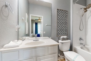 A bathroom with a white sink, toilet, and shower. - All-suite Retreat With Pool, Spa, Waterslides, Tennis - Near Dining & Disney (Kissimmee)