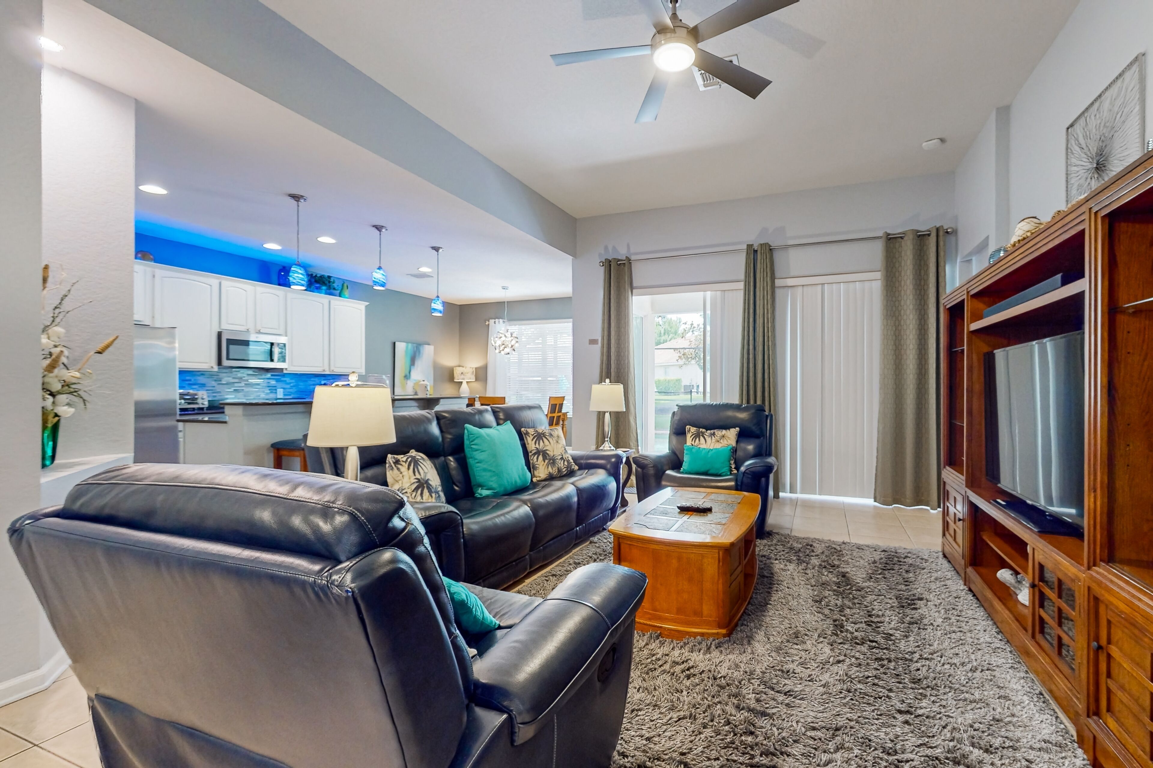 A modern living room with leather sofas, a wooden coffee table, and a television.