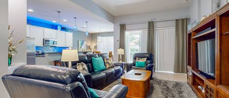 A modern living room with leather sofas, a wooden coffee table, and a television.
