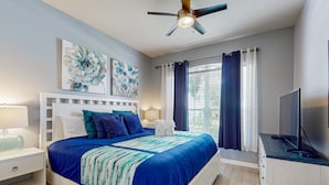 A bedroom with a bed, nightstands, a TV, and artwork on the wall. - All-suite Retreat With Pool, Spa, Waterslides, Tennis - Near Dining & Disney (Kissimmee)