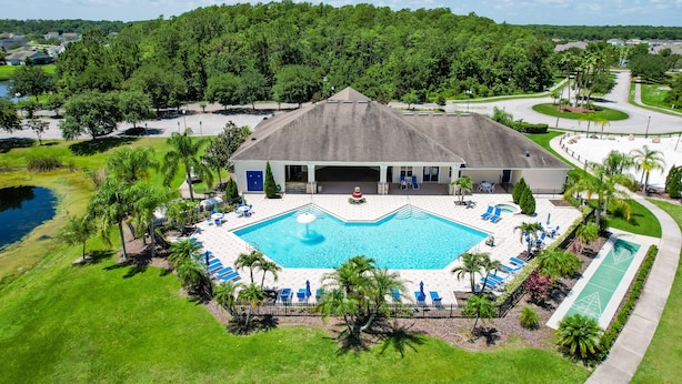 Ein Hotel mit Schwimmbad, Liegestühlen und Tennisplatz.