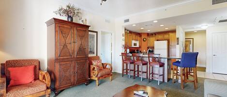 A spacious living room with a wooden cabinet, a sofa, a coffee table, and a ceiling fan.
