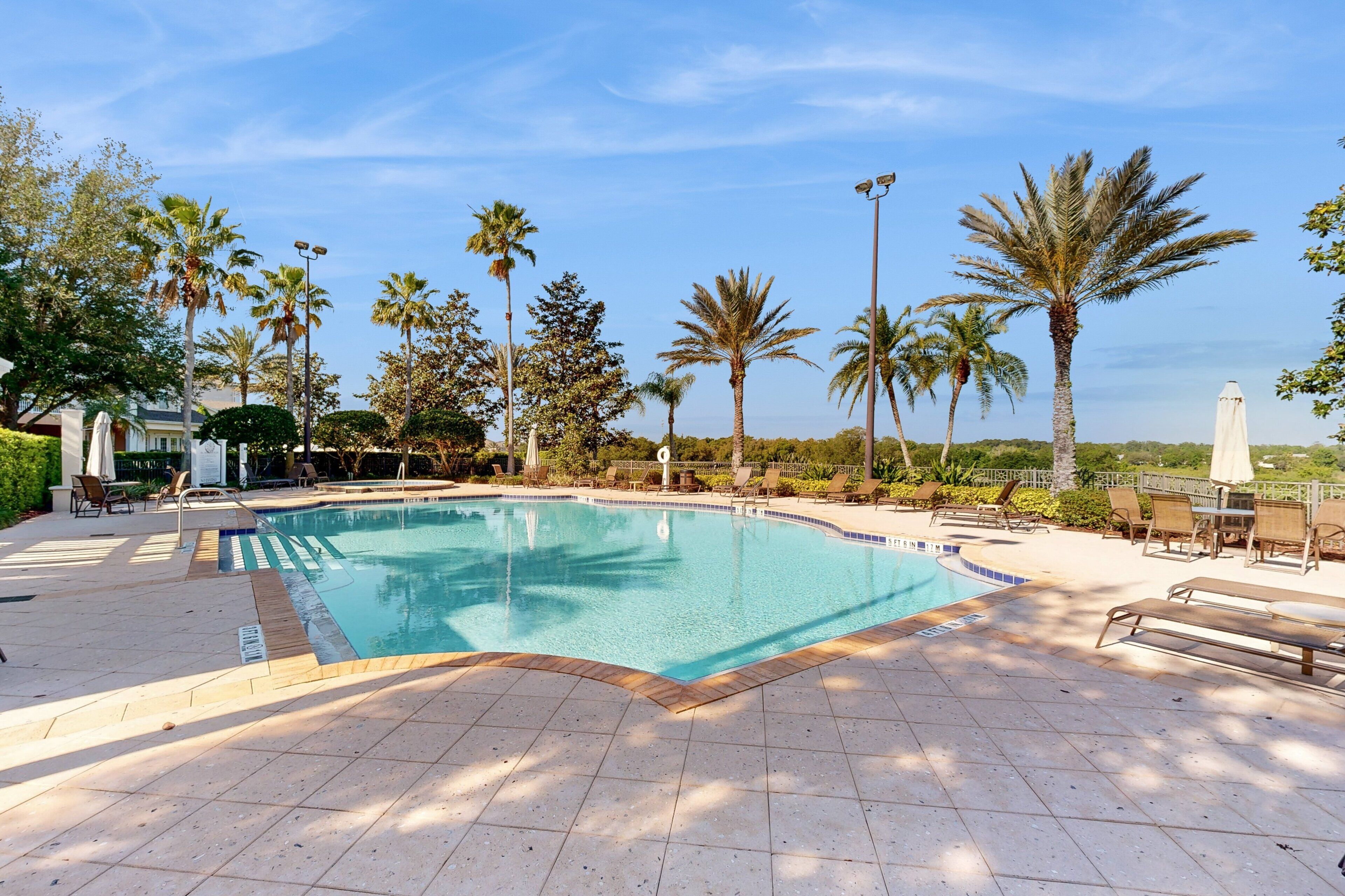 Ein Swimmingpool mit Liegestühlen und Palmen.