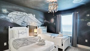 A bedroom with a galaxy-themed mural, two beds, a chandelier, and a window with curtains. - Relax & Play Resort Villa Magical 6-bedroom Retreat Near Disney! (Davenport)