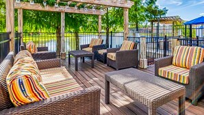 A covered outdoor seating area with wicker furniture and a pergola. - Beautiful & Spacious Resort Home in the Heart of Central FL (Kissimmee)