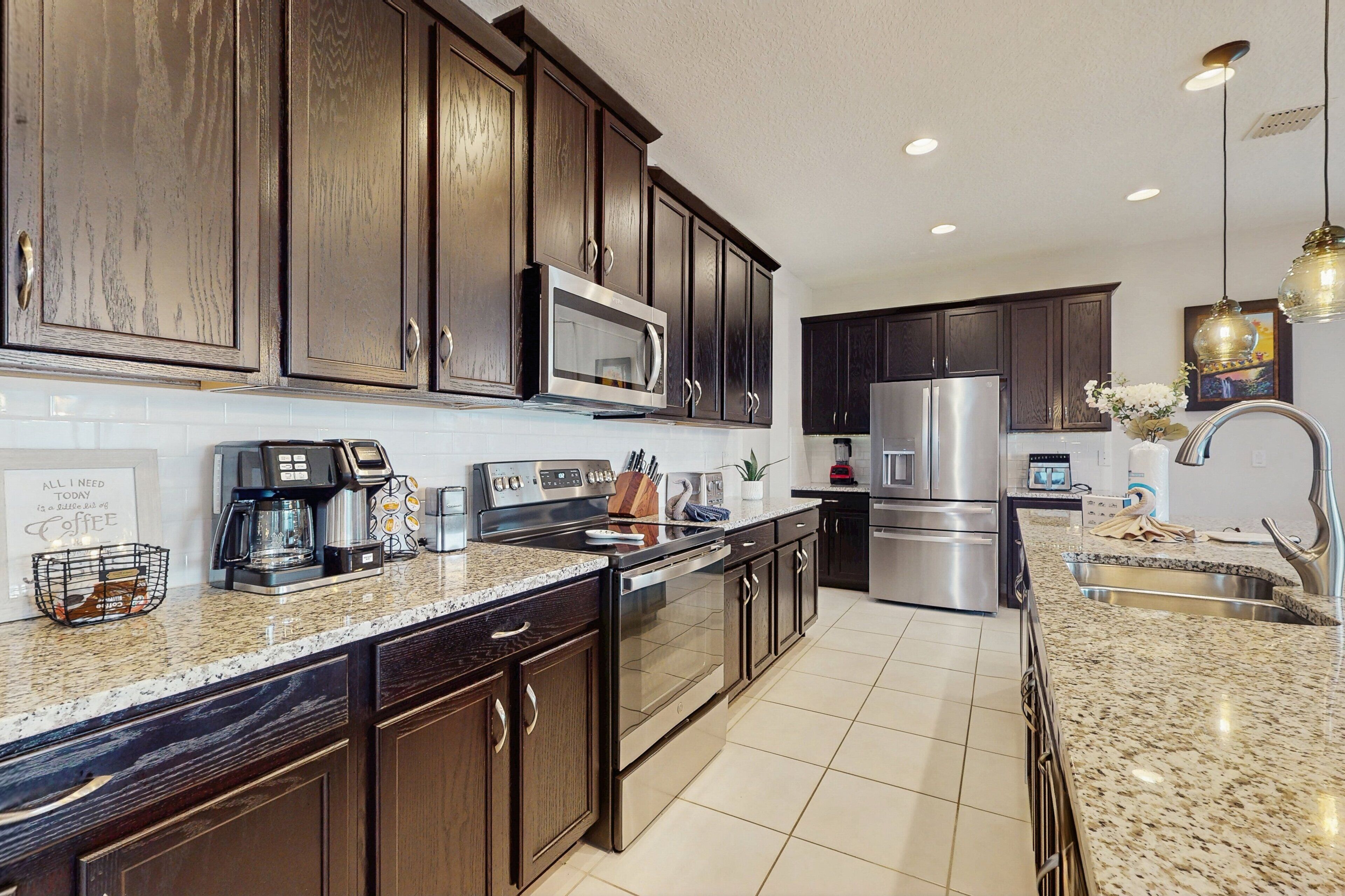 A modern kitchen with dark wood cabinets, stainless steel appliances, and a granite countertop.