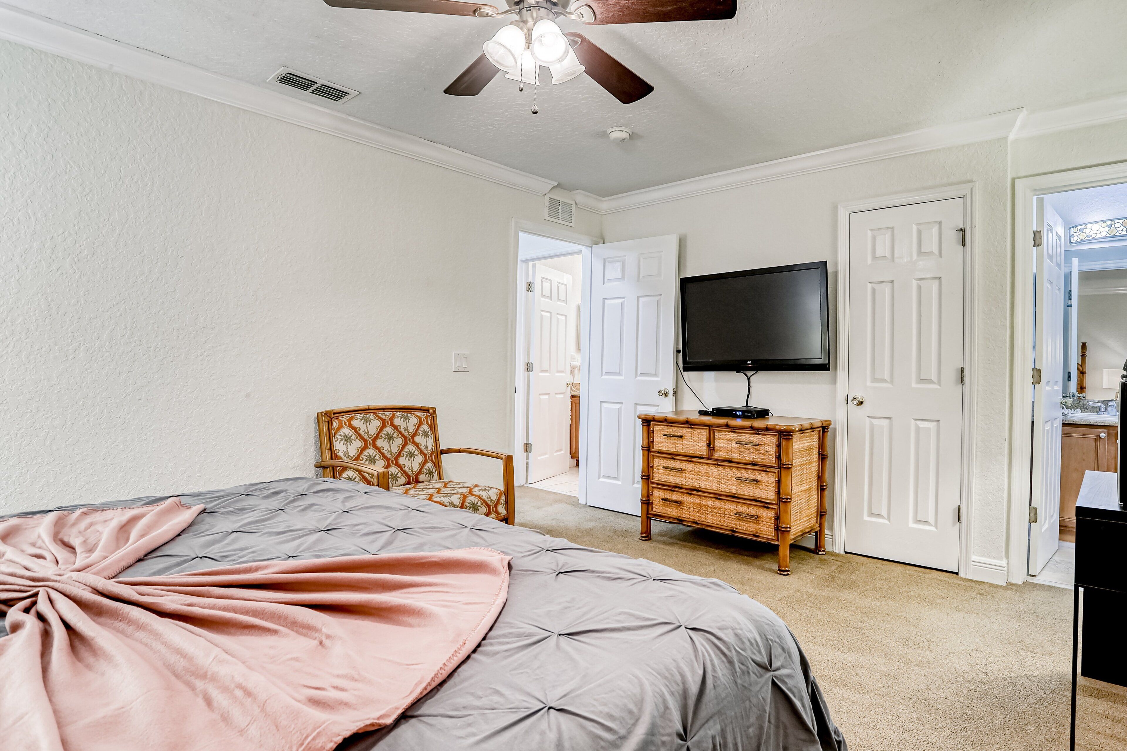 A bedroom with a bed, a television, a dresser, and a chair.