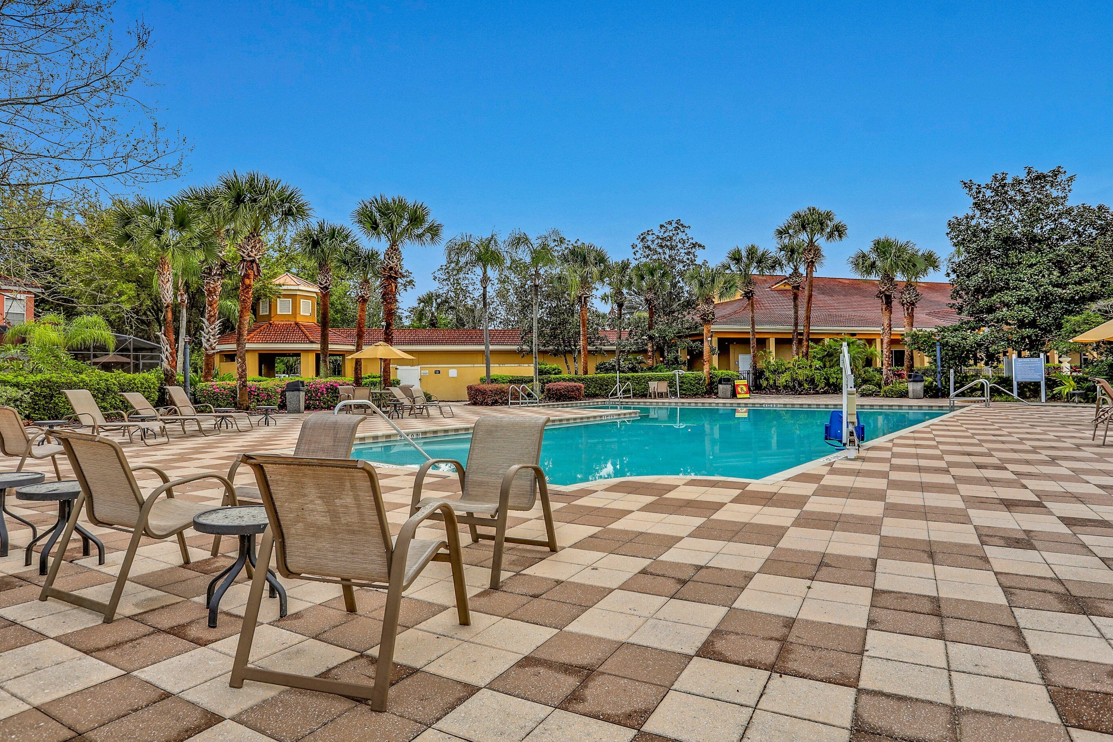 A pool area with lounge chairs and a checkered floor.