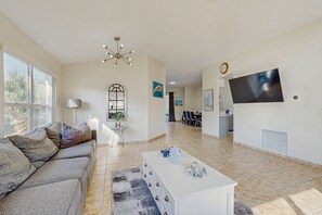 Ein geräumiges Wohnzimmer mit Sofa, Couchtisch und Fernseher.
