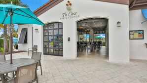 A bar and lounge named 'Tu Casa' with outdoor seating and a tiled patio. - Gorgeous Home With Private Pool With Spa, Pool Table & gas Grill (Kissimmee)