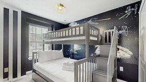 A bunk bed room with a starry wall mural, a window with blinds, and a hanging light fixture. - Beautiful Home With Private Pool and Space for the Whole Family (Davenport)