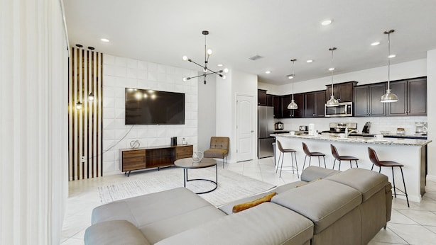 A modern kitchen with a central island, bar stools, and a dining area. - Beautiful Home With Private Pool and Space for the Whole Family (Davenport)