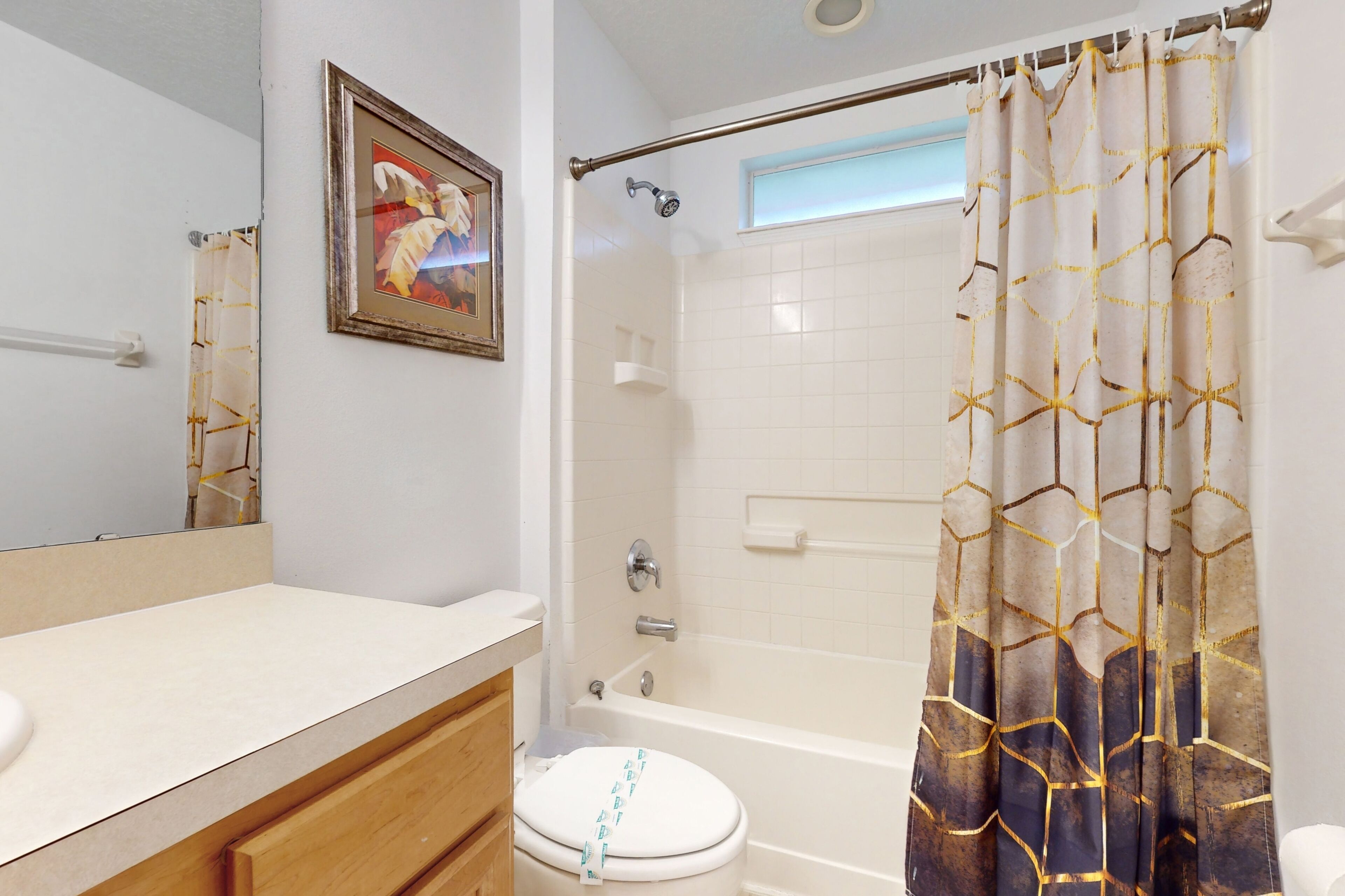 A bathroom with a toilet, a bathtub, and a shower curtain.