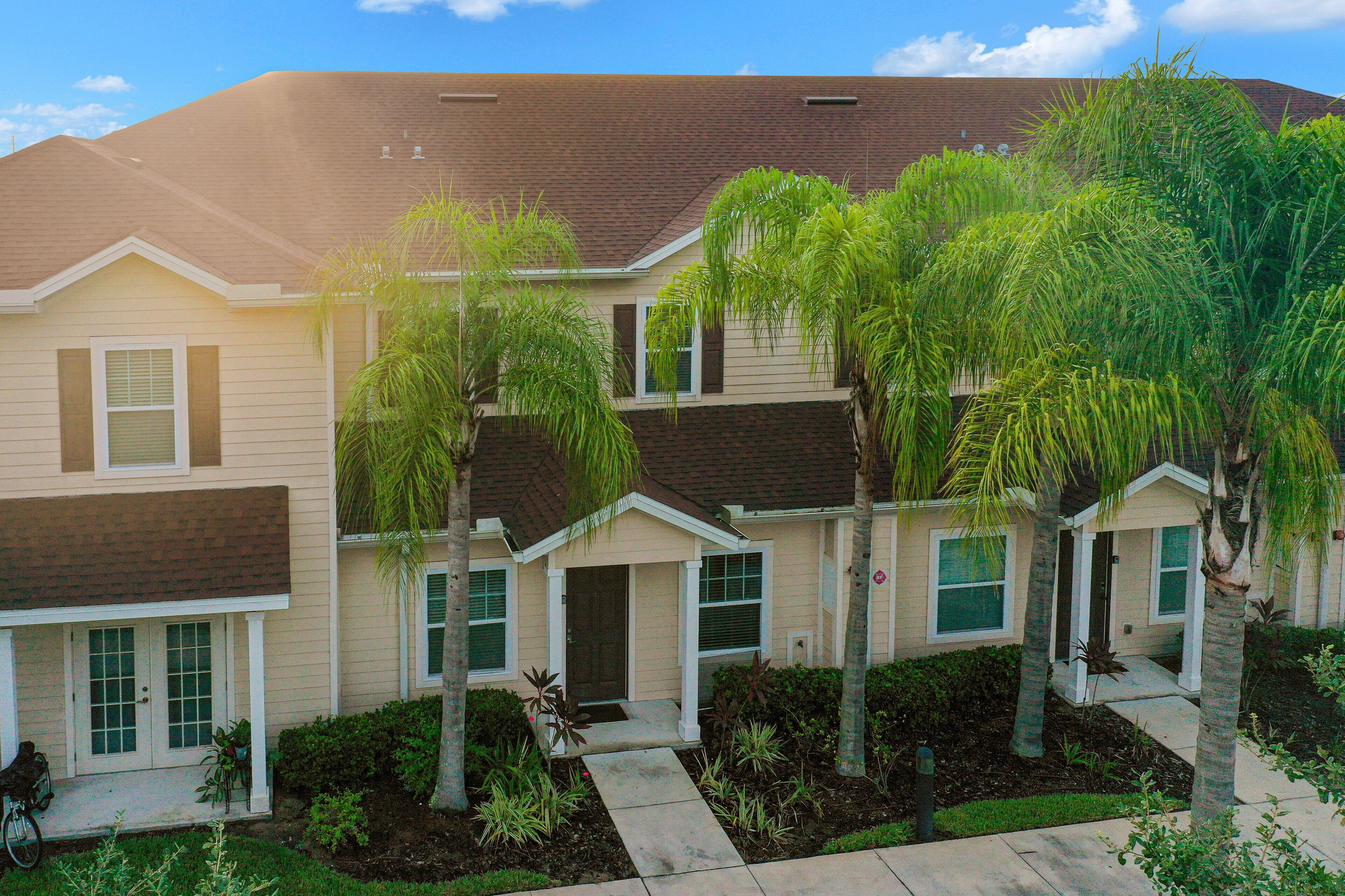 A residential building with a brick roof, multiple windows, and a front porch.