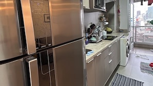 Een moderne keuken met roestvrijstalen apparatuur, een magnetron en een inbouwoven.
