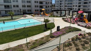A residential building with a swimming pool, playground, and landscaped garden. - Your Perfect Getaway in La Serena! (La Serena)