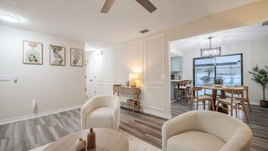 Ein modernes Interieur mit Essbereich, Deckenventilator und Blick ins Freie.