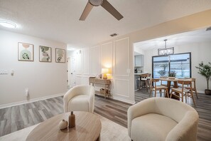 A modern interior with a dining area, a ceiling fan, and a view to the outside.