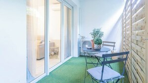A small patio area with a table, chairs, a potted plant, and a sliding glass door leading to an indoor space. - T2 -  Cocon du Lancier - Terrasse et Parking (Marseille)