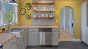 Une cuisine moderne équipée d’un lave-vaisselle, d’un plan de travail en bois et d’une fenêtre.