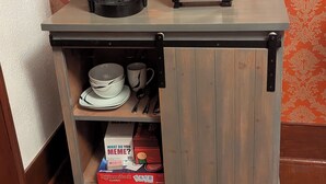 Una kitchenette con cafetera, tostadora y una caja de cápsulas de café Rombus Classic.