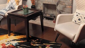Una sala de estar con chimenea de ladrillo, televisor de pantalla plana, sofá y una mesa de centro.