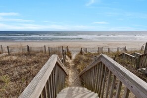 A wooden staircase leading to a beach with a wooden fence and a clear view of the ocean. - Clean & Modern Home w/ 2 King Suites, Elevator, & Short Walk to Beach (Surf City)