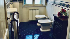 A bathroom with a window, a radiator, a toilet, a bidet, and a sink. - ANCIENT HOUSE OF NEL CHIANTI FOR 10 PEOPLE (Toscana)