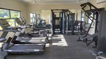 A gym with treadmills, weight machines, and a ceiling fan.