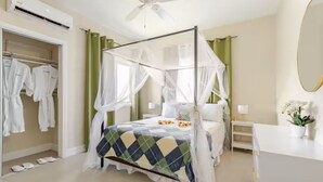 A four-poster bed with a canopy, a bedside table, a mirror, and a closet with hanging clothes. - Sunshine Seashore Escape Jamaica (Lucea)