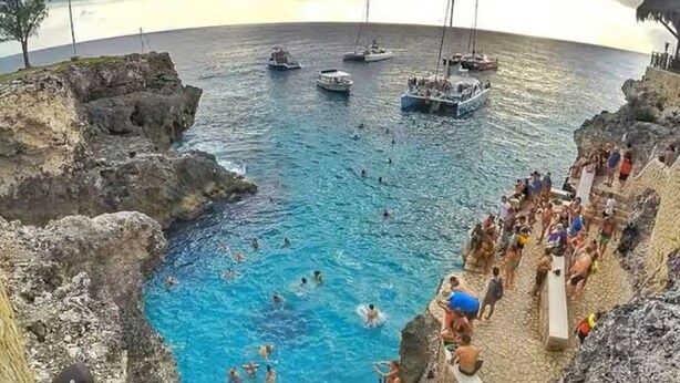 A coastal swimming area with boats and people. - Sunshine Seashore Escape Jamaica (Lucea)