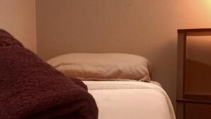 Una cama bien hecha con una toalla marrón doblada encima.