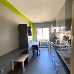 A narrow kitchen with a dining area, a bench, and a view to the outside. - Spacious Apt with High-Speed WiFi & Parking - Center (Casablanca)
