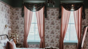 A bedroom with a bed, a bench, a dresser, and a mirror. - Historic District - Vintage Charm - Opal Suite (Hermann)