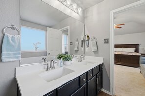 A bathroom with a double sink, a large mirror, and a ceiling fan. - Big Family Pool House Near DFW, Stockyards, Airport, Easy access to Hwy 35W (Fort Worth)