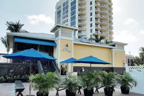 A building with a blue awning, a staircase, and a sign that reads 'Flippers.' - Lovers Key Resort 11th-Floor Waterfront Sanctuary-Pelicans Perch | Gorgeous Remodel | Pool & Hot Tub (Fort Myers Beach)