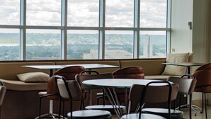 Ein modernes Interieur mit einem großen Fenster, einer Couch und einem Tisch mit Stühlen.