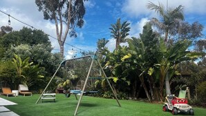 Ein Garten mit Schaukel, kleiner Spielzone und Spielzeugauto.