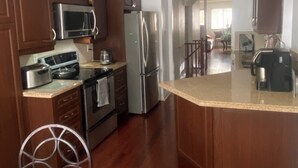 Una cucina con mobili in legno, elettrodomestici in acciaio inossidabile e un'isola centrale.