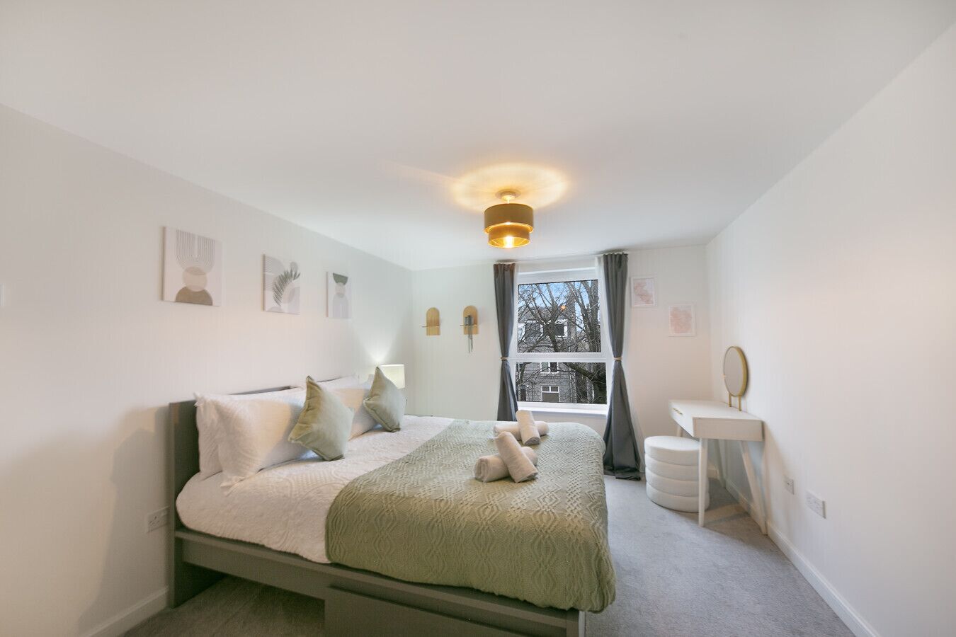 Ein Schlafzimmer mit Bett, Nachttisch und einem Fenster mit Vorhängen.